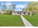 Ranch-style house with a well-maintained lawn and palm tree at 89 Hickory Hills Cir, Ormond Beach, FL 32174