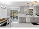 Updated kitchen with gray cabinets, white subway tile backsplash, and marble-look flooring at 89 Hickory Hills Cir, Ormond Beach, FL 32174