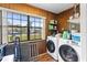 Laundry room with washer, dryer, and ample storage shelves at 89 Hickory Hills Cir, Ormond Beach, FL 32174