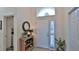 Bright entryway with wood console table, mirror, and access to laundry room at 1453 Sunningdale Ln, Ormond Beach, FL 32174