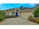 House exterior featuring a blue door and two-car garage at 1453 Sunningdale Ln, Ormond Beach, FL 32174