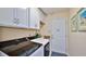 Laundry room with white cabinets, LG washer and dryer, and access to the outside at 1453 Sunningdale Ln, Ormond Beach, FL 32174