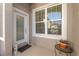 Front entrance with white door, window, and small potted plant at 1510 Kinnard Cir, Ormond Beach, FL 32174