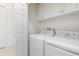 Bright laundry room with washer and dryer, white cabinets, and ample storage at 3238 Bailey Ann Dr, Ormond Beach, FL 32174