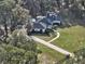 Aerial view of a home showcasing its expansive lawn, winding driveway, and partially shaded surroundings at 7024 Sw 93Rd Street Rd, Ocala, FL 34476