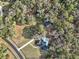Stunning aerial view of a house with a pool and well-maintained grounds surrounded by lush trees at 7024 Sw 93Rd Street Rd, Ocala, FL 34476