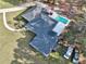 Aerial view of a home with a pool, long driveway, and multiple vehicles in a large yard at 7024 Sw 93Rd Street Rd, Ocala, FL 34476