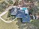 Aerial view of a house featuring a pool, red umbrella, and circular driveway at 7024 Sw 93Rd Street Rd, Ocala, FL 34476