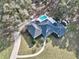 Aerial view of a house with pool, patio and long driveway surrounded by trees at 7024 Sw 93Rd Street Rd, Ocala, FL 34476