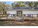 Large wooden deck with seating offers a relaxing outdoor space with a view of the yard and trees at 7024 Sw 93Rd Street Rd, Ocala, FL 34476