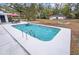 Spacious backyard features a pool with ladder, patio seating, and a large lawn area at 7024 Sw 93Rd Street Rd, Ocala, FL 34476