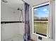 This bathroom has a glass shower and a window with pastoral view at 7024 Sw 93Rd Street Rd, Ocala, FL 34476