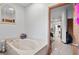 Bathroom showcasing the neutral soaking tub with views into a light-filled living space at 7024 Sw 93Rd Street Rd, Ocala, FL 34476