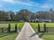 Picturesque home with a long driveway and lush green lawn, featuring a gated entrance at 7024 Sw 93Rd Street Rd, Ocala, FL 34476