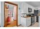 Well-lit kitchen featuring white cabinets, butcher block countertops, and modern appliances with a view of a pink bedroom at 7024 Sw 93Rd Street Rd, Ocala, FL 34476