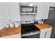 Well-equipped kitchen features stainless steel appliances, a range hood, and butcher block countertops at 7024 Sw 93Rd Street Rd, Ocala, FL 34476