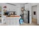 Compact kitchen featuring white cabinetry, open shelving, and stainless steel appliances, for easy cooking at 7024 Sw 93Rd Street Rd, Ocala, FL 34476