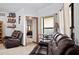 Comfortable living room featuring leather sofa, shelves, and a view into a bedroom at 7024 Sw 93Rd Street Rd, Ocala, FL 34476