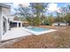 Backyard pool with patio, red umbrella, outdoor seating, fire pit, and expansive lawn at 7024 Sw 93Rd Street Rd, Ocala, FL 34476