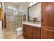 Bathroom with a walk-in shower, toilet and a wood cabinet at 990 Downshire Ln, Ormond Beach, FL 32174