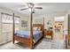 Bedroom with wooden post bed, ceiling fan, and view of the kitchen at 1031 Calle Grande St, Ormond Beach, FL 32174