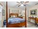 Bedroom with wooden post bed, ceiling fan, and access to the kitchen at 1031 Calle Grande St, Ormond Beach, FL 32174