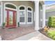 Brick porch with red door and columns at 1068 Hampstead Ln, Ormond Beach, FL 32174