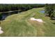 Aerial view of a golf course with a pond at 1068 Hampstead Ln, Ormond Beach, FL 32174