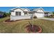 Landscaped front yard with a flagpole and brick-lined flower bed at 11977 Se 91St Cir, Summerfield, FL 34491