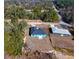 An aerial view of a colorful single-story home with a new roof in a wooded, rural setting at 211 Oak Lane Loop, Ocala, FL 34472