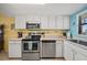 Condo kitchen with stainless steel appliances and white cabinets at 3100 Ocean Shore Blvd # 5020, Ormond Beach, FL 32176