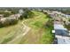 Aerial view of homes and a golf course with a walking path at 4546 Nottoway Dr, Leesburg, FL 34748