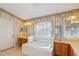 Main bathroom with double vanity, bathtub and window at 4546 Nottoway Dr, Leesburg, FL 34748