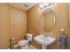 Small bathroom with toilet, sink, and oval mirror at 4546 Nottoway Dr, Leesburg, FL 34748