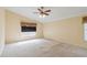 Large carpeted bedroom with ceiling fan and window at 4546 Nottoway Dr, Leesburg, FL 34748