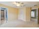 Carpeted bedroom with pale yellow walls and ceiling fan at 4546 Nottoway Dr, Leesburg, FL 34748