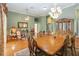 Bright dining room adjacent to living room with hardwood floors and chandelier at 4546 Nottoway Dr, Leesburg, FL 34748