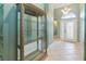 Bright entryway with tile flooring, glass-front cabinet, and elegant front door at 4546 Nottoway Dr, Leesburg, FL 34748