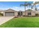 Front view of a single story house with a gray garage door and palm trees at 4546 Nottoway Dr, Leesburg, FL 34748