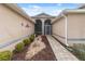 Front entry walkway with landscaping and stone path at 4546 Nottoway Dr, Leesburg, FL 34748