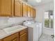 Bright laundry room, washer, dryer, cabinets, and utility sink at 4546 Nottoway Dr, Leesburg, FL 34748