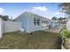 Landscaped backyard with a manicured lawn, white fence, and patio at 149 Sunrise Cove Cir, Ormond Beach, FL 32176