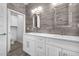 Bathroom with double vanity, white cabinets, and wood-look tile at 149 Sunrise Cove Cir, Ormond Beach, FL 32176