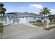 Single-story home with light blue exterior, two-car garage, and palm trees at 149 Sunrise Cove Cir, Ormond Beach, FL 32176