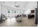 Bright living room with wood look floors, modern ceiling fan, lots of natural light, and access to the kitchen at 149 Sunrise Cove Cir, Ormond Beach, FL 32176