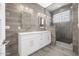 Modern main bathroom with a dual sink vanity, wood look tile, and a frameless glass shower enclosure at 149 Sunrise Cove Cir, Ormond Beach, FL 32176