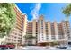 Exterior of a tall, light beige condominium building with parking and landscaping at 2403 S Atlantic Ave # 309, Daytona Beach, FL 32118