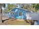 Cute blue house with a white picket fence and two teal chairs on a patio at 825 Magnolia Ave, Holly Hill, FL 32117