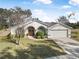 Single-story house with arched entryway, two-car garage, and neat landscaping at 92 Spinnaker Cir, South Daytona, FL 32119