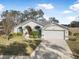 Single-story house with arched entryway, two-car garage, and well-maintained lawn at 92 Spinnaker Cir, South Daytona, FL 32119